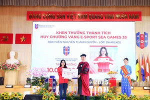 GS.TS Nguyễn Đức Trung, Hiệu trưởng Trường Đại học Ngân hàng TPHCM, trao phần thưởng của nhà trường cho Nguyễn Thanh Duyên. Ảnh: HUB