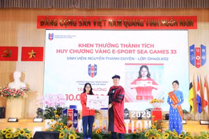 GS.TS Nguyễn Đức Trung, Hiệu trưởng Trường Đại học Ngân hàng TPHCM, trao phần thưởng của nhà trường cho Nguyễn Thanh Duyên. Ảnh: HUB