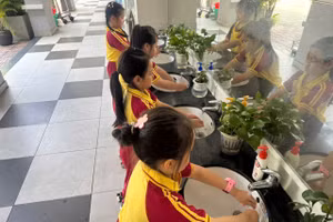 Học sinh Trường Tiểu học Hồ Văn Huê (phường Đức Nhuận, TPHCM) rửa tay sau khi tham gia hoạt động ngoài trời.