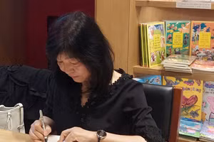 Nhà văn Shin Kyung Sook ký tặng tiểu thuyết 'Hãy chăm sóc mẹ' cho độc giả Việt Nam. Ảnh: Bình Thanh