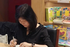 Nhà văn Shin Kyung Sook ký tặng tiểu thuyết 'Hãy chăm sóc mẹ' cho độc giả Việt Nam. Ảnh: Bình Thanh