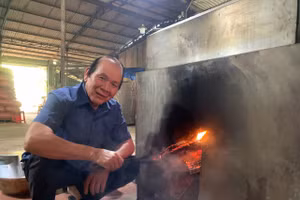 Ông Hoàng Chuẩn bên máy rang hạt điều bằng củi do ông sáng chế. Ảnh: NVCC