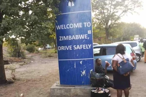 Người dân Zimbabwe ngồi nghỉ ở biên giới giữa Zimbabwe và Zambia.