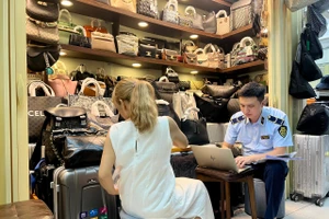 Lực lượng quản lý thị trường kiểm tra hàng giả tại Trung tâm Thương mại Saigon Square. Ảnh: QLTT TPHCM