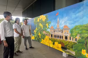 Họa sĩ Ngô Bá Hoàng (giữa) tại triển lãm 'Chào Việt Nam - Quê hương tôi'. Ảnh: BTC.