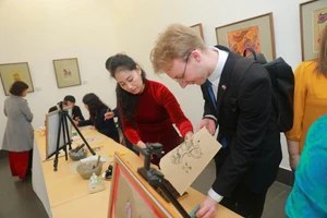 Du khách trải nghiệm in tranh ngựa tại triển lãm chuyên đề 'Ngựa trong Nghệ thuật tạo hình' ở Bảo tàng Mỹ thuật Việt Nam. Ảnh: BTC.