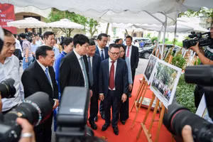 Ông Lê Quốc Minh - Tổng Biên tập Báo Nhân Dân giới thiệu với đoàn tham quan về bức ảnh họp lớp của cố Tổng Bí thư Nguyễn Phú Trọng dưới gốc cây đa 71 Hàng Trống vào năm 2022. Ảnh: BTC.