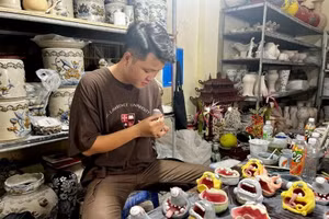 Vũ Tuấn Long đang trang trí cho các sản phẩm “quái dị” của mình. Ảnh: QĐND