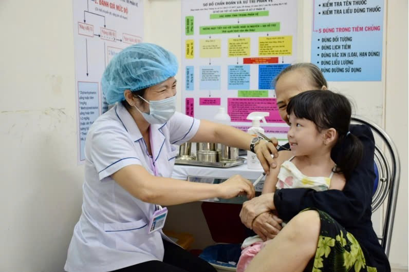 Phụ huynh đưa trẻ đi tiêm vaccine sởi. (Ảnh: SYT)
