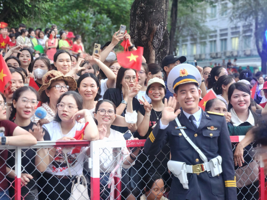 Dòng người mang theo cờ đỏ sao vàng, mặc áo in hình Tổ quốc xếp hàng tạo nên không gian rực lửa. 1000128124.jpg