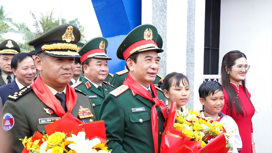 Bộ trưởng Phan Văn Giang và Bộ trưởng Tea Seiha nhận hoa từ thầy, trò Trường Tiểu học Bến Cầu. (Ảnh: H.L)