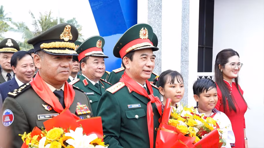 Bộ trưởng Phan Văn Giang và Bộ trưởng Tea Seiha nhận hoa từ thầy, trò Trường Tiểu học Bến Cầu. (Ảnh: H.L)