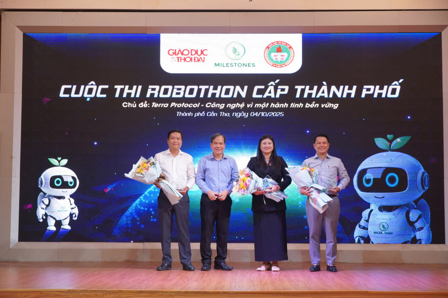 Nhà báo Nguyễn Xuân Lộc (bên phải), Phụ trách Văn phòng đại diện Báo Giáo dục và Thời đại tại ĐBSCL và Ban Tổ chức cuộc thi nhận hoa chúc mừng. z7080441324055-32762a141ced25bf6fc07d5d5157541f.jpg