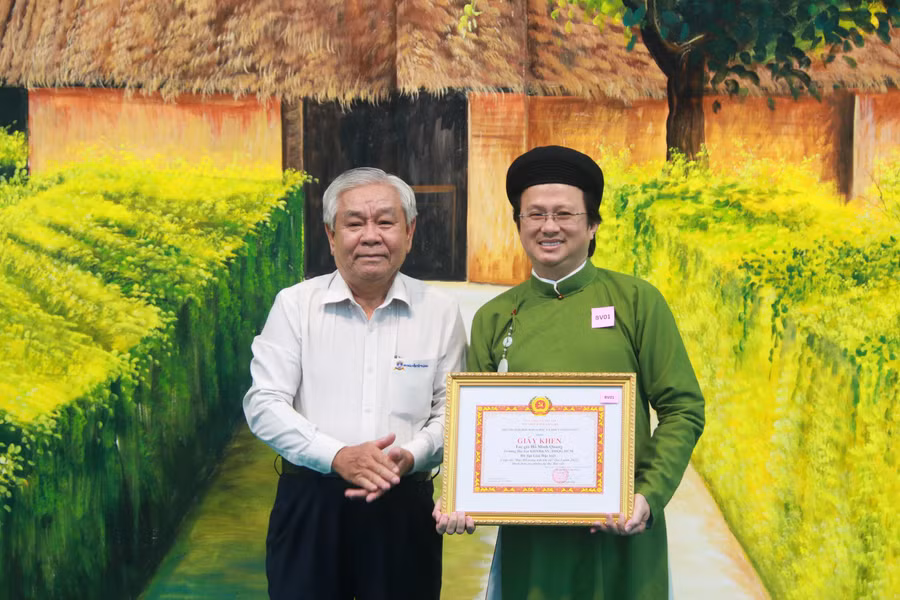 Ông Thái Văn Cư - Phó Bí thư Đảng ủy Trường Đại học Nguyễn Tất Thành trao giải Đặc biệt ở hạng mục bài viết cho TS Hồ Minh Quang- nguyên trưởng khoa Khoa Đông Phương học (phải). (Ảnh: VNUHCM)