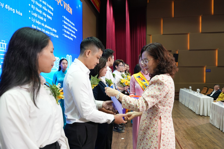 TS. Đồng Sĩ Thiên Châu, Phó Hiệu trưởng Trường Đại học Tôn Đức Thắng trao hoa và thư chúc mừng các tân nghiên cứu sinh, tân học viên.