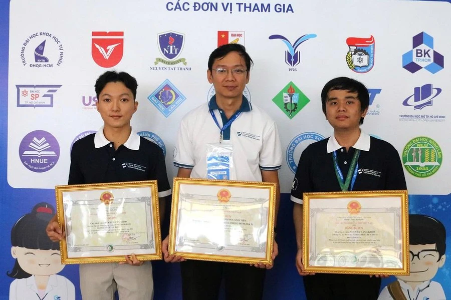 Sinh viên Nguyễn Văn Khoa (bìa trái) nhận giải thưởng thủ khoa cuộc thi Olympic Sinh học sinh viên Việt Nam. (Ảnh: VNUHCM)