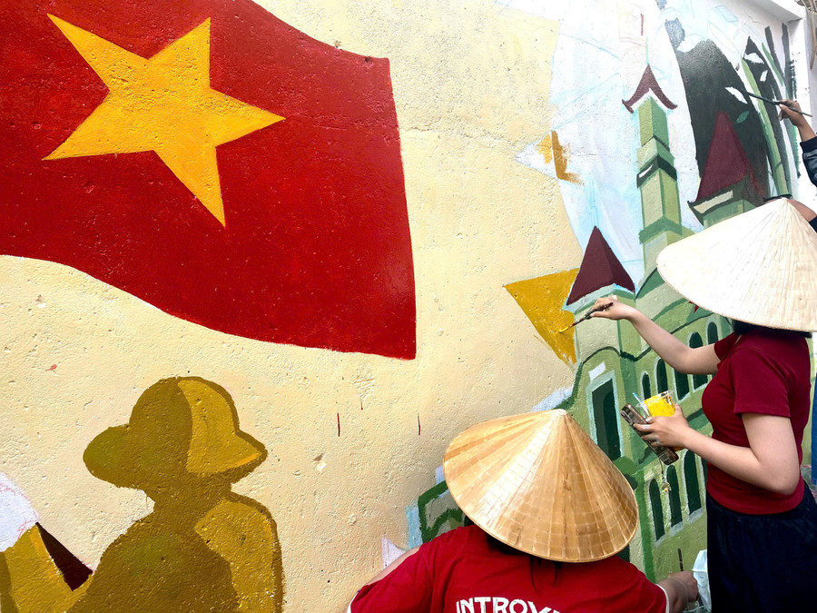 Lại Hương Xuân (sinh viên năm 4, khoa Mỹ thuật tạo hình, Trường Đại học Mỹ thuật TPHCM) chia sẻ, mảng tường trung tâm với hình ảnh cờ Đảng, cờ Tổ quốc và trụ sở UBND TPHCM được các chiến sĩ dồn nhiều tâm huyết nhất, nhằm gửi gắm lòng tự hào dân tộc. Ảnh: Khánh Vy.