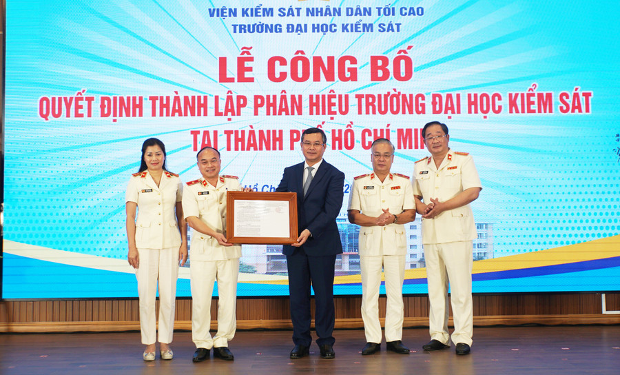 Thứ trưởng Bộ GD&ĐT Nguyễn Văn Phúc trao quyết định thành lập Phân hiệu Trường Đại học Kiểm sát tại TPHCM cho tập thể nhà trường. Ảnh: Mạnh Tùng.