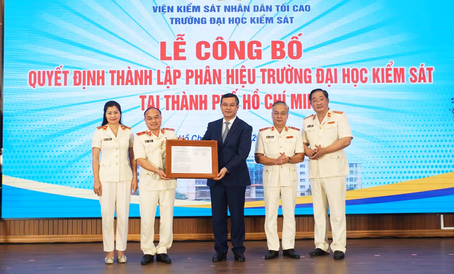 Thứ trưởng Bộ GD&ĐT Nguyễn Văn Phúc trao quyết định thành lập Phân hiệu Trường Đại học Kiểm sát tại TPHCM cho tập thể nhà trường. Ảnh: Mạnh Tùng.