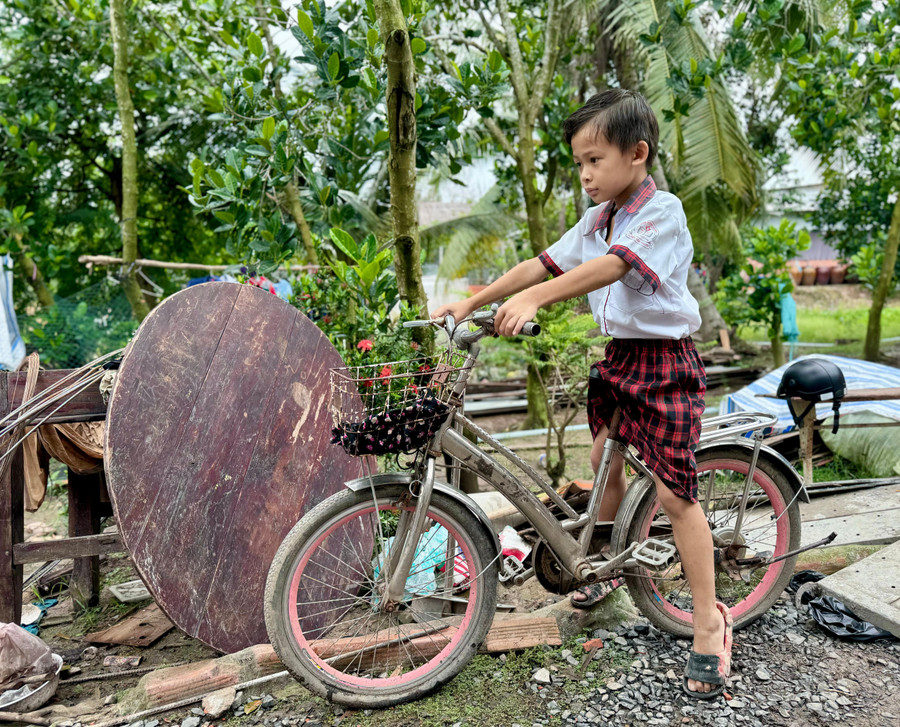 Nguyễn Đại Phong trên chiếc xe đạp đi học hằng ngày của em. Ảnh: Thùy Linh.