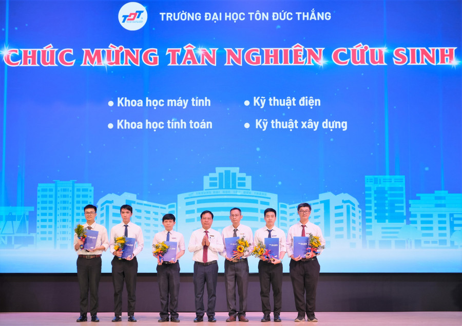TS Vũ Anh Đức, Bí thư Đảng ủy, Chủ tịch Hội đồng trường trao thư chúc mừng cho các tân nghiên cứu sinh tiến sĩ. ncs.jpg