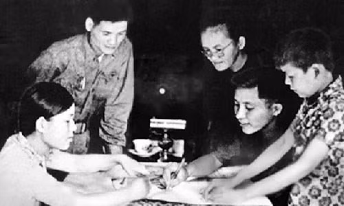 Má Sáu Ngẫu (thứ ba, từ phải sang) cung cấp tấm bản đồ và hướng dẫn đường tiến quân vào Sài Gòn cho chỉ huy Trung đoàn 27. Ảnh: Tư liệu Báo Quân đội Nhân dân.