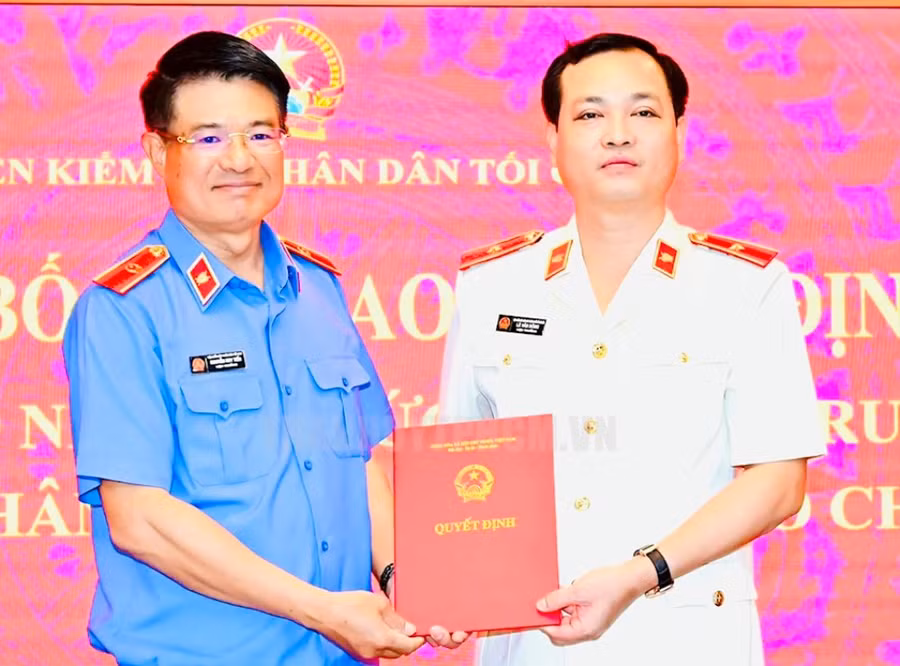 Viện trưởng Viện KSND tối cao Nguyễn Huy Tiến (trái) trao quyết định cho ông Lê Văn Đông. (Ảnh: HCMCPV)