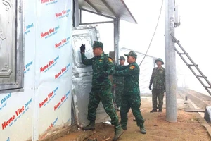 Cán bộ, chiến sĩ Đồn Biên phòng Pa Ủ giúp người dân bản Cờ Lò sửa chữa nhà sau trận mưa đá.