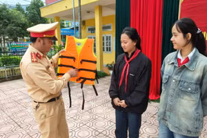 Cán bộ Phòng Cảnh sát Giao thông Công an tỉnh Lai Châu hướng dẫn học sinh cách sử dụng áo phao.