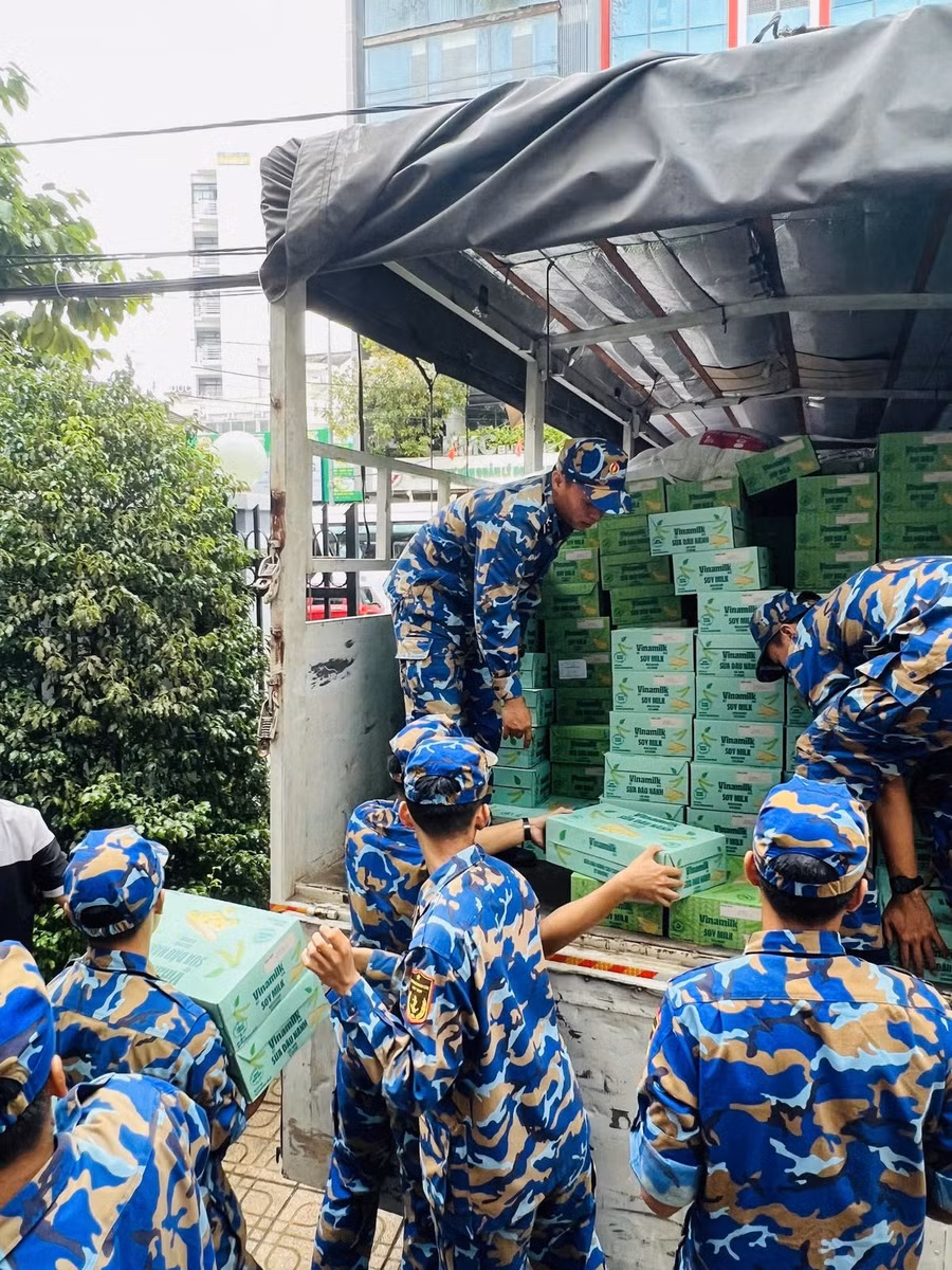 Các chiến sĩ Trung tâm Huấn luyện Vùng 4 Hải quân đang chuyền nhau các sản phẩm dinh dưỡng Vinamilk, sẵn sàng vận chuyển đến tận tay bà con vùng lũ - Ảnh: Vi Nam