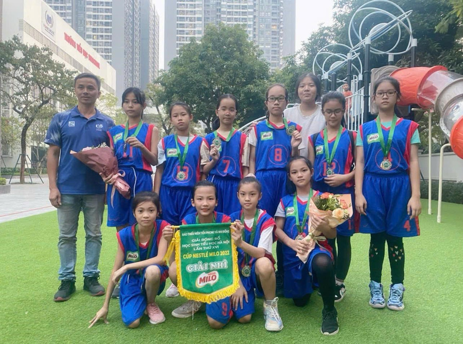 Hơn cả thành tích, tinh thần đồng đội và những bài học có được từ thể thao sẽ giúp Trà My (cầm cờ) cùng các bạn nhỏ thành công trong cuộc sống. Ảnh: NVCC bong-da-2.jpg