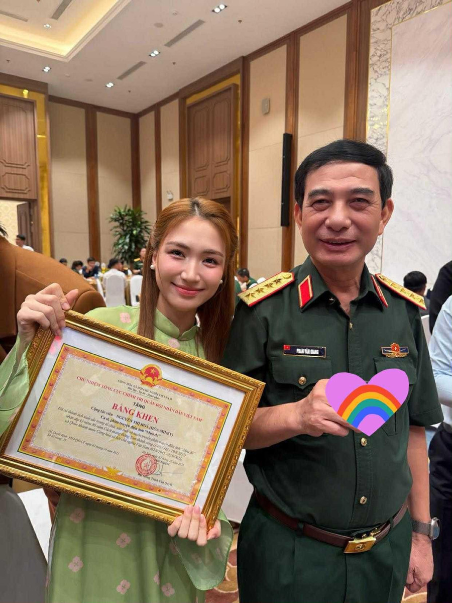 Nữ ca sĩ Hòa Minzy đứng cạnh Bộ trưởng Bộ Quốc phòng Phan Văn Giang, bày tỏ niềm tự hào khi nhận bằng khen. hoa-minzy-3.jpg