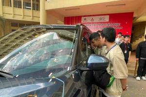Sinh viên Trường Đại học Bình Dương bên chiếc ô tô được tài trợ phục vụ thực hành. Ảnh: Hà An.