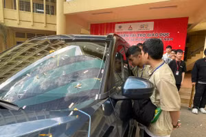 Sinh viên Trường Đại học Bình Dương bên chiếc ô tô được tài trợ phục vụ thực hành. Ảnh: Hà An.