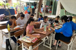 Những bạn trẻ mang áo xanh tình nguyện dạy học cho em nhỏ ở xóm trọ phường Thảo Điền, TPHCM. Ảnh: Phúc Uyên.