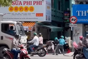 Nhóm người đánh nhau loạn xạ trên đường Hậu Giang, trong đó có một số người mặc áo xe ôm công nghệ. (Ảnh cắt từ clip)