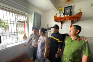 Ông Mai Quang, Phó Chủ tịch UBND phường Bình Quới (trái) cùng lực lượng chức năng vận động người dân Chung cư Thanh Đa tháo dỡ "chuồng cọp". Ảnh: Hà An.