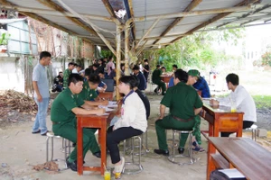 Bộ đội Biên phòng Cửa khẩu Quốc tế Mộc Bài tiếp nhận công dân Việt Nam từng làm việc ở Campuchia. (Ảnh: Phúc Uyên)