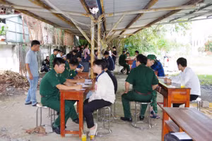 Bộ đội Biên phòng Cửa khẩu Quốc tế Mộc Bài tiếp nhận công dân Việt Nam từng làm việc ở Campuchia. (Ảnh: Phúc Uyên)