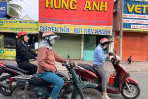 Người dân TPHCM mặc áo ấm ra đường sáng nay. Ảnh: Phúc Uyên