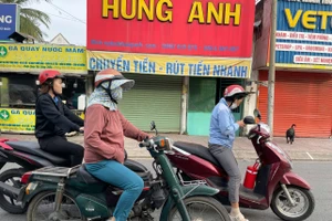 Người dân TPHCM mặc áo ấm ra đường sáng nay. Ảnh: Phúc Uyên