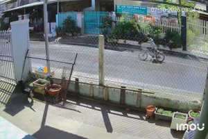 Bé trai đạp xe đuổi theo người giật vé số trong bất lực. (Ảnh cắt từ clip).