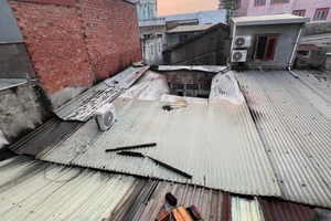 Lực lượng chức năng phải cắt mái tôn để đưa vòi xịt dập tắt ngọn lửa.