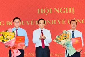 Ông Phạm Thành Kiên (phải) và ông Lê Quốc Phong nhận quyết định từ Bí thư Thành ủy TPHCM Trần Lưu Quang. Ảnh: SGGP