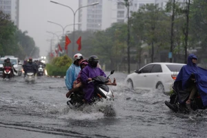 Mưa trái mùa xuất hiện trên diện rộng ở TPHCM khiến nhiều đường ngập nặng, người dân khó khăn đi lại, đúng giờ tan tầm.