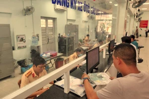 Người dân thực hiện thủ tục đăng ký xe tại TPHCM. Ảnh: TTXVN.