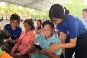 Đoàn viên thanh niên hướng dẫn người cao tuổi sử dụng các ứng dụng hành chính công trên điện thoại tại sự kiện. Ảnh: Hà An.