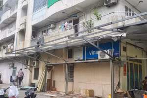 Người dân ở chung cư Độc Lập tự tháo dỡ phần mái che cơi nới sau vụ cháy khiến 8 người chết xảy ra hôm 6/7. (Ảnh: Phúc Uyên)