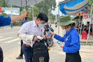 Học sinh được các anh chị đoàn viên tiếp nước khi vào làm thủ tục thi tại Trường THPT Nguyễn Trãi. Ảnh: Hà An.