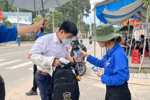 Học sinh được các anh chị đoàn viên tiếp nước khi vào làm thủ tục thi tại Trường THPT Nguyễn Trãi. Ảnh: Hà An.